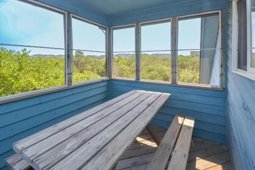 a wooden bench sitting in a room with windows at Misty Blue - Corolla, Ocean Sands, 200 Yards to Beach, Ocean View, Pets OK, Flex Stays Year Rnd in Corolla