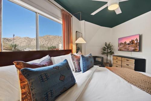 a bedroom with a bed with a large window at Rockaway Mesa Dome Views Pool Karaoke Sauna in Yucca Valley