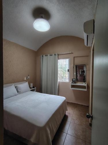 a bedroom with a large bed and a window at Casa Paraíso in Ixtapa