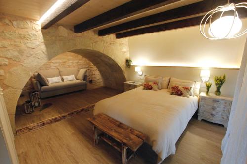a bedroom with a large bed and a couch at "Dobela Enea" Cueva alojamiento privado in Laguardia