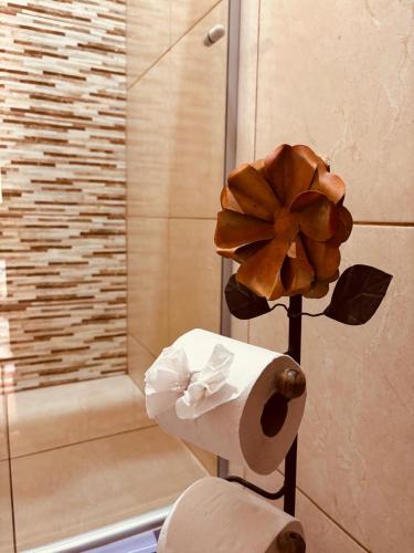 a roll of toilet paper and a flower in a bathroom at Bosque Love in Juatuba
