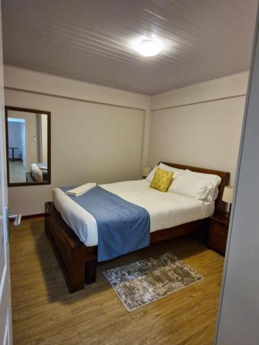 a bedroom with a bed and a mirror at Gaborone Platinum Self Catering in Gaborone