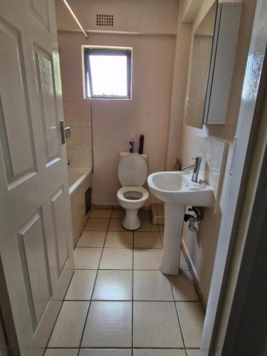 a bathroom with a toilet and a sink at Gaborone Platinum Self Catering in Gaborone