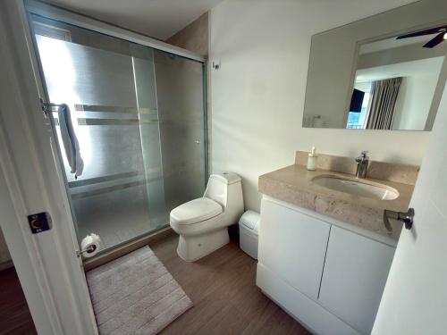 a bathroom with a toilet and a sink and a shower at Spacious Central Apartment, Pool & Gym, Group Friendly in Hermosillo