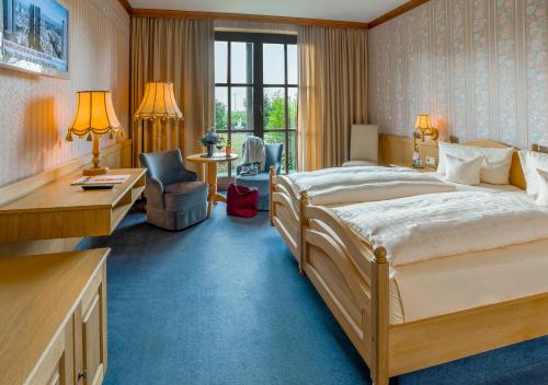 a hotel room with a large bed and a desk at Krone am Park - Gästehaus des Hotel Krone in Alzenau in Unterfranken