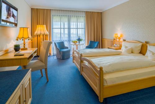 a hotel room with a bed and a desk at Krone am Park - Gästehaus des Hotel Krone in Alzenau in Unterfranken