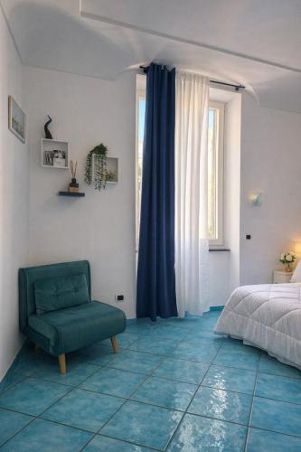 a bedroom with a green chair and a bed at In centro - De Jusola apartment in Maiori