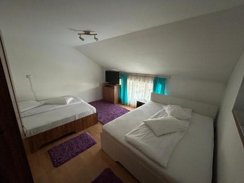 a bedroom with two beds and a window at Casa in Bucovina in Gura Humorului