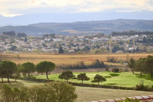 a golf course with a town in the background at Résidence Le Petit Duc in Carcassonne