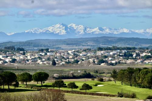 a view of a golf course with mountains in the background at Résidence Le Petit Duc in Carcassonne