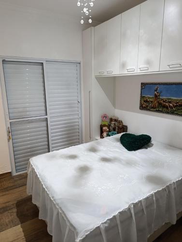 a white bedroom with a large white bed in it at Chácara Paraíso in Itupeva