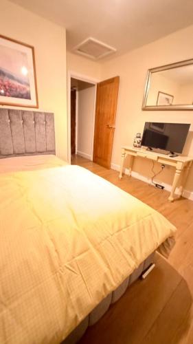a bedroom with a large bed and a desk at OYO Royal Lodge Maidstone in Maidstone