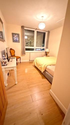 a bedroom with a bed and a desk and a window at OYO Royal Lodge Maidstone in Maidstone