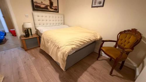 a small bedroom with a bed and a chair at OYO Royal Lodge Maidstone in Maidstone
