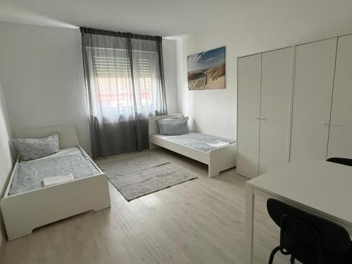 a white room with two beds and a desk at Ferienwohnung Rheinglück in Oppenheim
