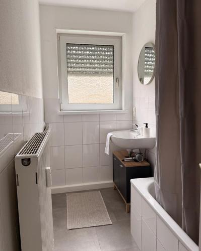 a white bathroom with a sink and a window at Ferienwohnung Rheinglück in Oppenheim