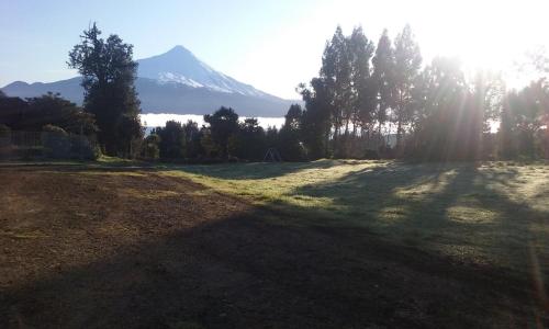 a large field with a mountain in the background at Cabañas Los Volcanes Ensenada Puerto Varas in Ensenada