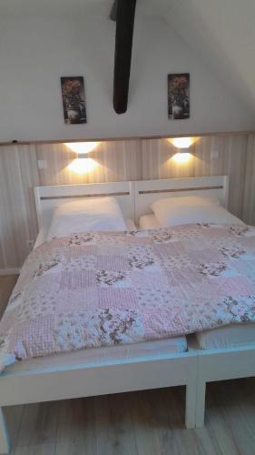 a white bed with two pillows on top of it at Apartmenthaus Rosenflair in Schönebeck