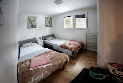a bedroom with two beds and two windows at Chata Bella Donovaly in Donovaly