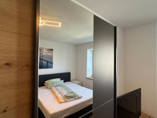 a small bedroom with a bed and a mirror at Ferienwohnung Wanderlust in Marsberg