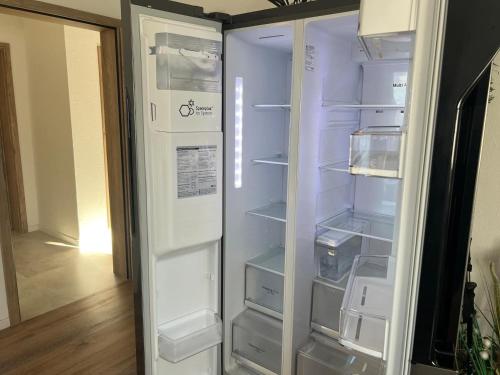 an empty refrigerator with its door open in a room at Ferienwohnung Wanderlust in Marsberg