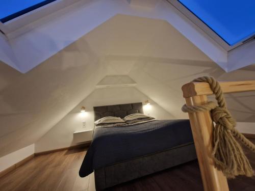 ein Schlafzimmer mit einem Bett im Dachgeschoss in der Unterkunft Lake Loft in Żarnowska