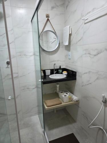 a bathroom with a sink and a shower with a mirror at Conforto e Sofisticação à Beira Mar in Cabedelo