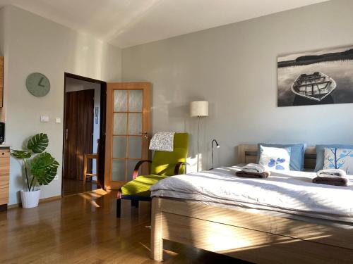 a bedroom with a large bed and a green chair at Apartmán u Horynů - Sadová in Česká Třebová