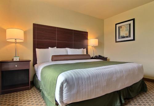a hotel room with a large bed and two lamps at Cobblestone Inn & Suites - Carrington in Carrington