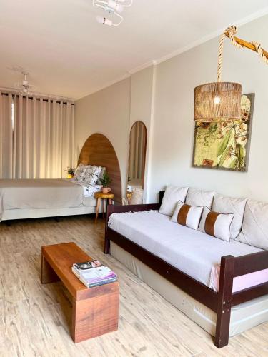 a living room with a bed and a couch at Apto estúdio na praça central in Serra Negra