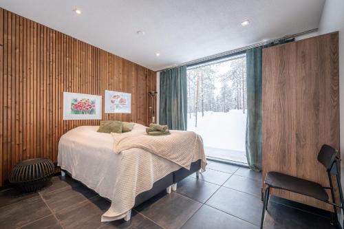 a bedroom with a bed and a large window at Arctic Villas Ruka in Kuusamo
