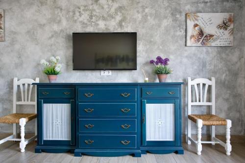 a blue dresser with a television on top of it at Apartamentos Turisticos Ilusiones 2 in Cazalla de la Sierra