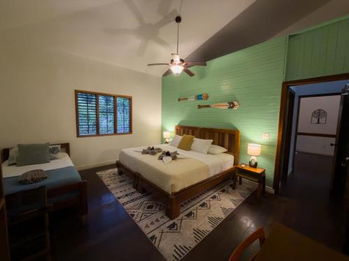 a bedroom with a bed and a green wall at Conchy Tonk in Bocas Town