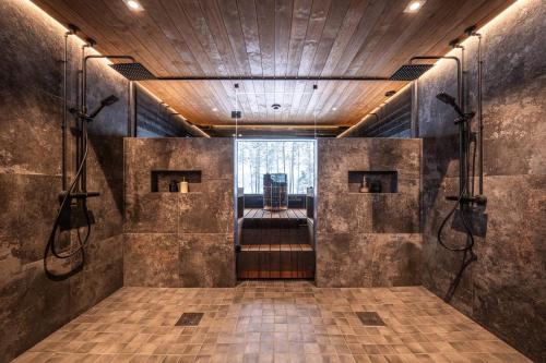 a walk in shower in a room with a window at Arctic Villas Ruka in Kuusamo