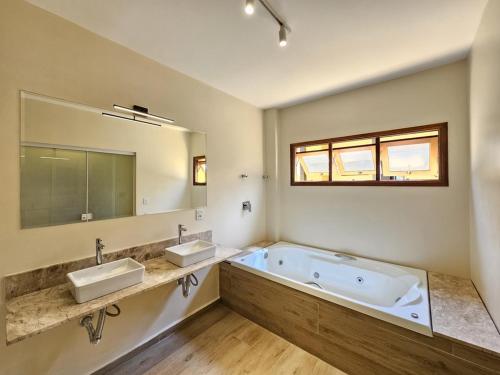 a large bathroom with two sinks and a tub at Ilha Flat Hotel in Ilhabela
