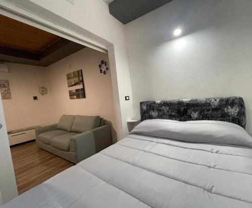 a bedroom with a large bed and a chair at Luma Sixty nine in Alcamo