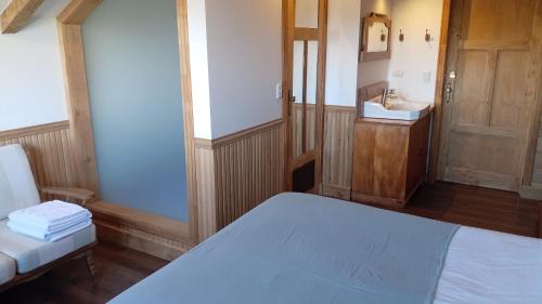 a small room with a bed and a sink at Hotel Boutique Casa Werner in Puerto Varas