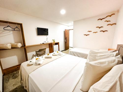 a hotel room with two beds and bats on the wall at Pousada D'Azul in Japaratinga