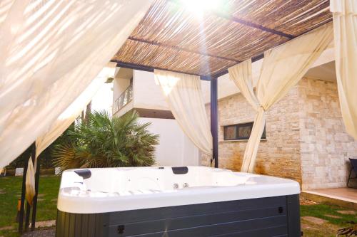 a bath tub in a yard with curtains at SanPietro Vacation Rentals in Draç