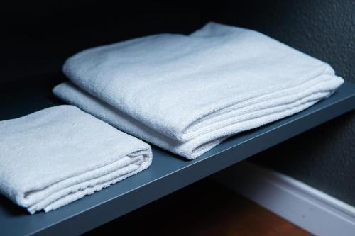 two stacks of white towels sitting on a shelf at Hotel 10 Blumenau in Blumenau