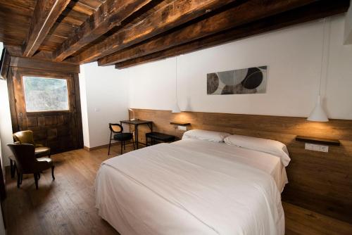 a bedroom with a white bed and a table at Palacio Soran in Leintz-Gatzaga