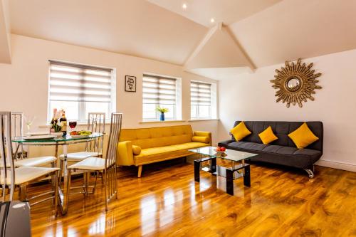 a living room with a yellow couch and a table at Exclusive Apartment in Newcastle upon Tyne