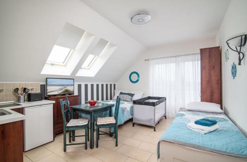 a bedroom with a bed and a table and a kitchen at Willa Di Mare in Karwia