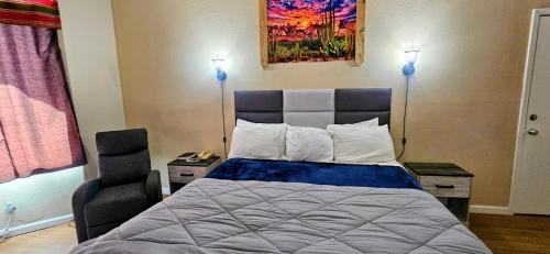 a bedroom with a bed and a chair at Rodeway Inn Roswell in Roswell