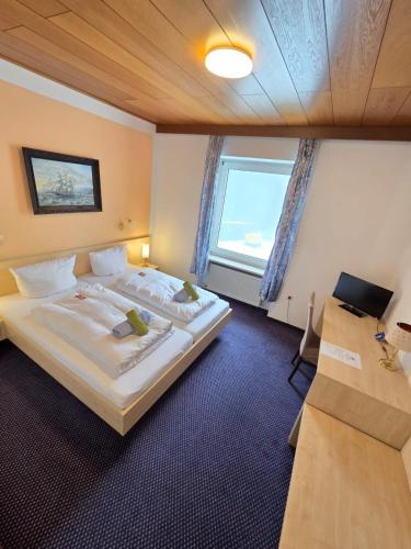 a bedroom with a large bed and a window at Hotel BURGWALD in Passau