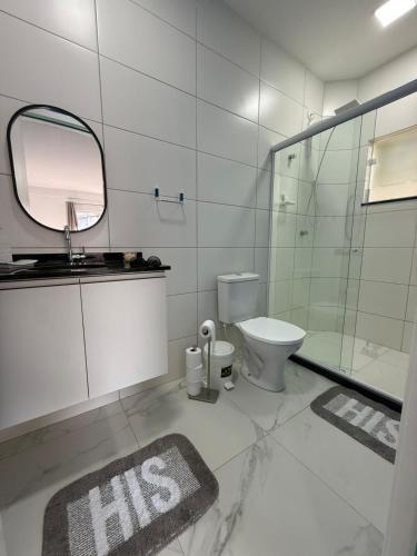 a bathroom with a toilet and a sink and a mirror at Condomínio Aparte Hotel Laguna in Arraial do Cabo
