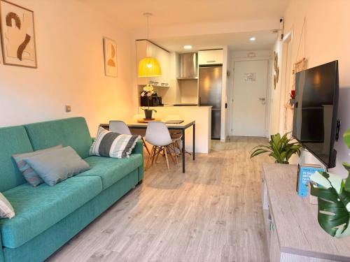 ein Wohnzimmer mit einer grünen Couch und einer Küche in der Unterkunft El Foraió in L'Estartit