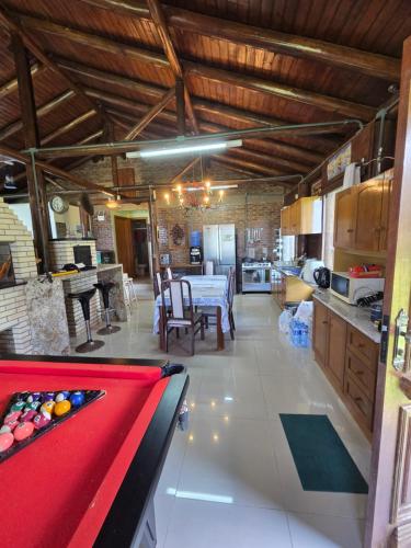 a living room with a pool table and a kitchen at Cabana da lagoa in Osório