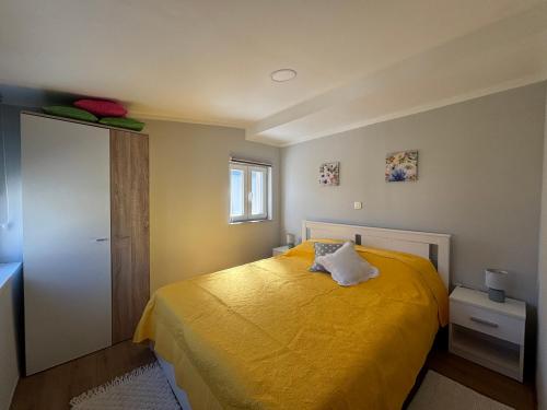 a bedroom with a yellow bed and a window at Happy Home LP in Gruda