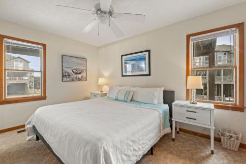a bedroom with a bed and two windows at The Pickled Mermaid in Rodanthe